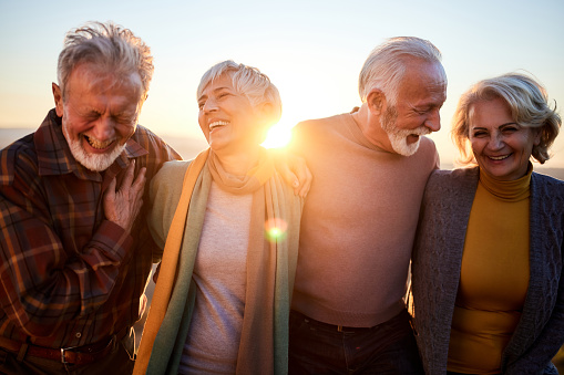 Happy mature couples talking while walking in autumn day.